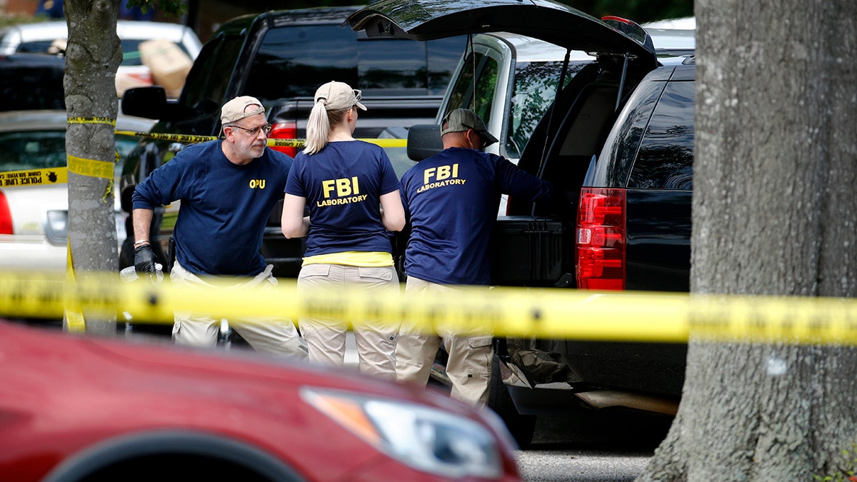 Members of the FBI load equipment into a vehicle as they work in a parking lot outside a municipal building that was the scene of a shooting, Saturday, June 1, 2019, in Virginia Beach, Va. (AP Photo/Patrick Semansky)