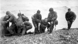 Soldiers carry troop onto beach during D-Day