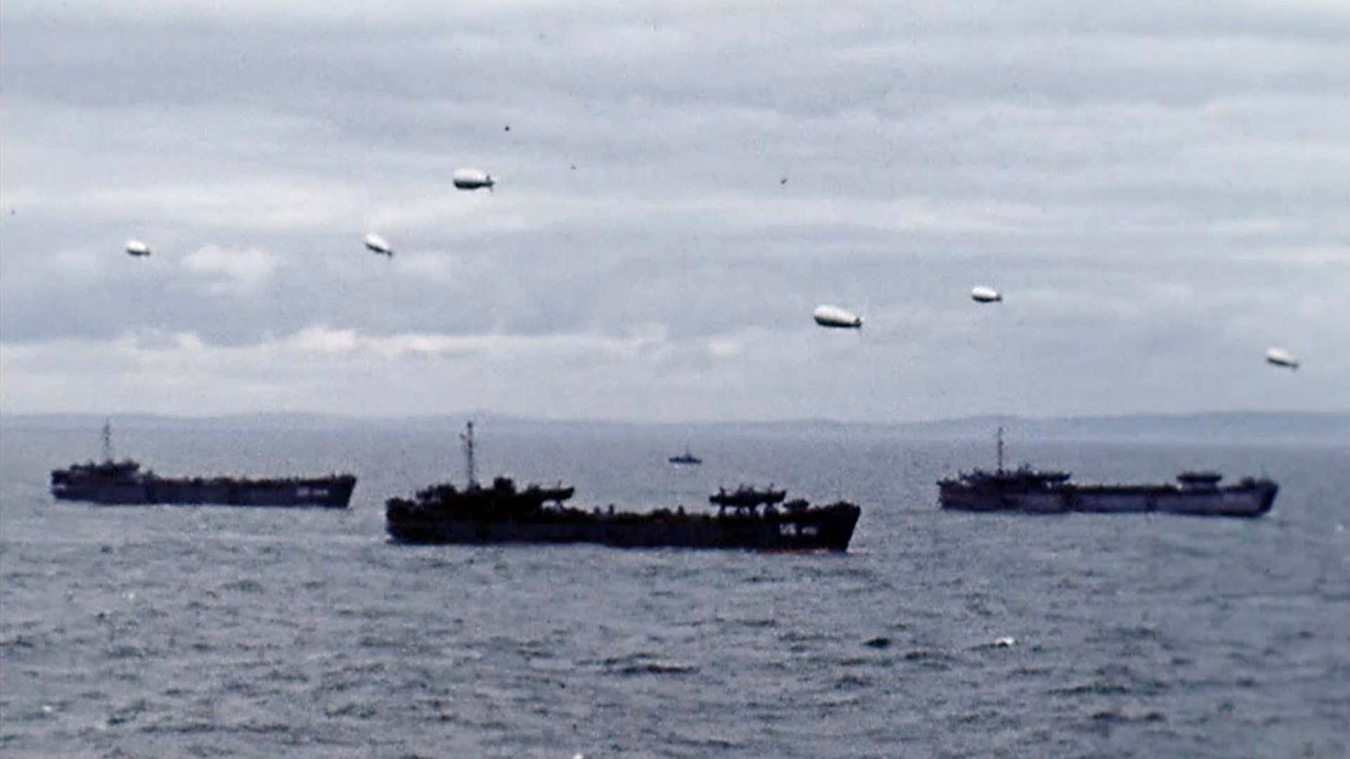 War ships and blimps carrying soldier travel to Normandy, France