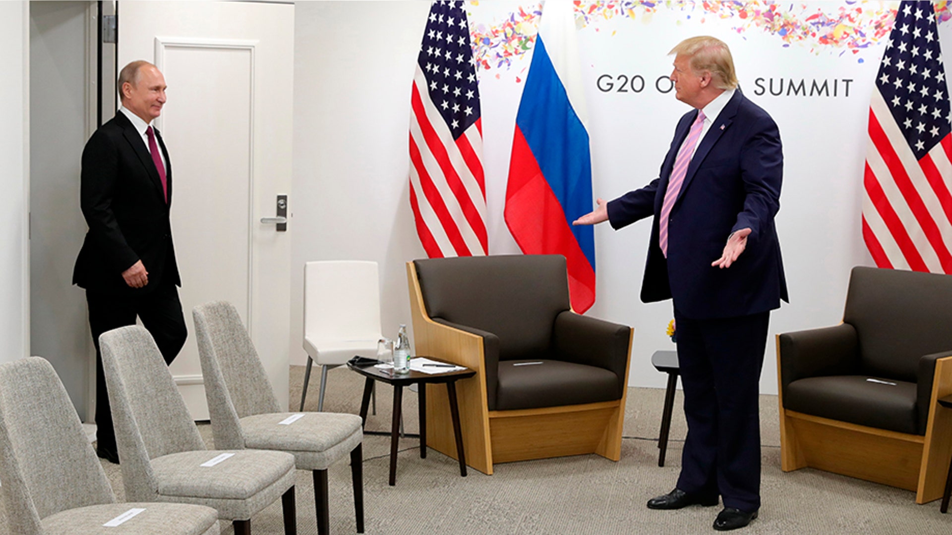 President Donald Trump gestures as Russian President Vladimir Putin arrives for talks during a bilateral meeting on the sidelines of the G-20 summit in Osaka, Japan, June 28, 2019.