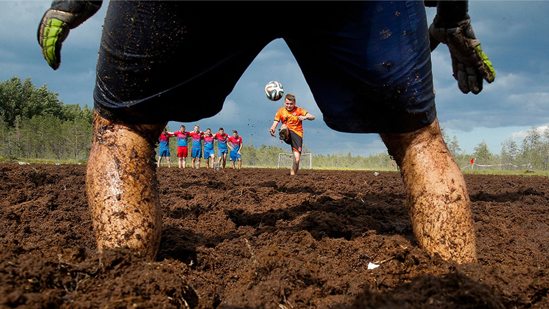 A swamp soccer player kicks a penalty shot during a swamp soccer tournament in Pogy village, near St. Petersburg, Russia, June 22, 2019. 