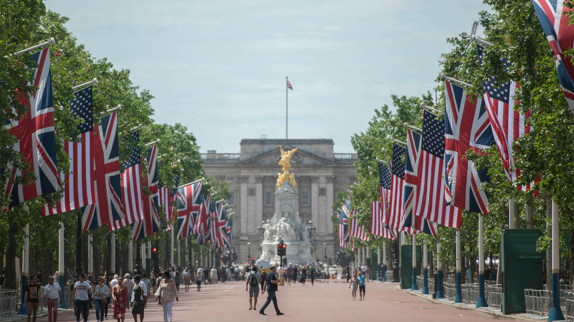National flags of Britain and the U.S. lining the thoroughfare leading to the gilded Queen Victoria Monument in front of Buckingham Palace in London.