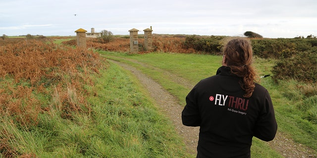 Flying drone over remains of the old gates at Sylt, drone operator in the foreground, Alderney. — SNI/SI Networks L.L.C.