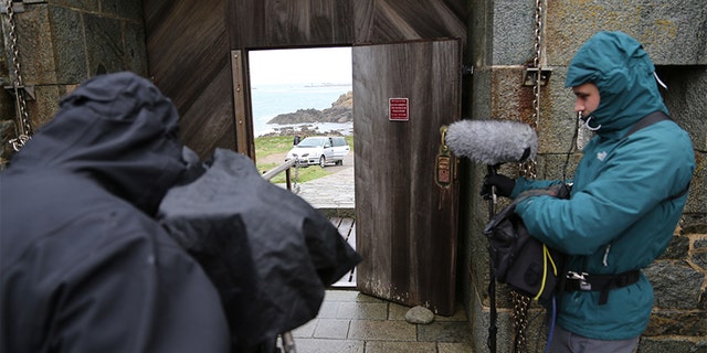 Caroline Sturdy Colls returning to base, Alderney — filming through gate doors. — SNI/SI Networks L.L.C.