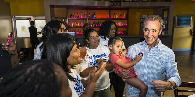 Joe Morrissey, right, with his daughter Bella, 3, celebrates his Democratic primary win in 16th District State Senate race with his supporters at the election party of Plaza Mexico in Petersburg, Va., Tuesday, June 11, 2019.
