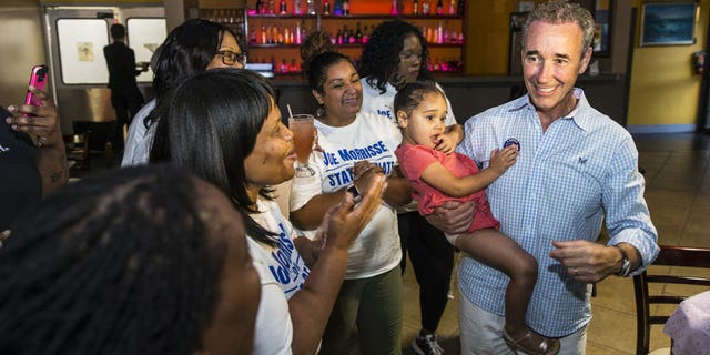 Joe Morrissey, right, with his daughter Bella, 3, celebrates his Democratic primary win in 16th District State Senate race with his supporters at the election party of Plaza Mexico in Petersburg, Va., Tuesday, June 11, 2019.