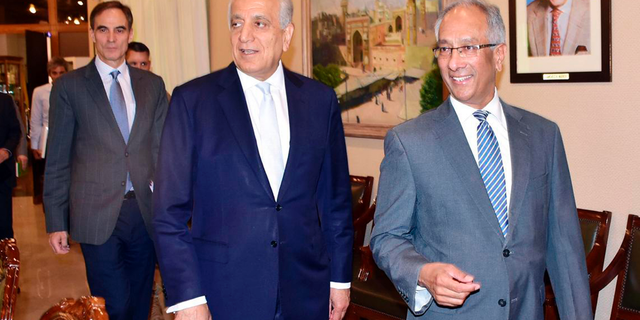 In this photo released by the Foreign Office, Pakistan's Foreign Ministry official Aftab Khokhar, right, escorts visiting Special Representative for Afghanistan Reconciliation Zalmay Khalilzad, center, for talks at the Foreign Office in Islamabad, Pakistan, Sunday, June 2, 2019. Khalilzad has met Pakistani officials to find a peaceful solution to neighboring Afghanistan's war. (Pakistan Foreign Office via AP)