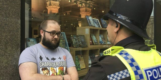 Paul Crowther speaks to police after Brexit Party leader Nigel Farage was hit with a milkshake during a campaign rally in Newcastle, England, Monday May 20, 2019.