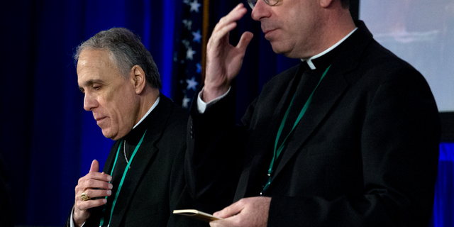 Cardinal Daniel DiNardo, left, of the Archdiocese of Galveston-Houston, president of the United States Conference of Catholic Bishops accompanied by Rev. J. Brian Bransfield, participates in a morning prayer, during the United States Conference of Catholic Bishops (USCCB), 2019 Spring meetings in Baltimore, Tuesday, Jun 11, 2019. (AP Photo/Jose Luis Magana)