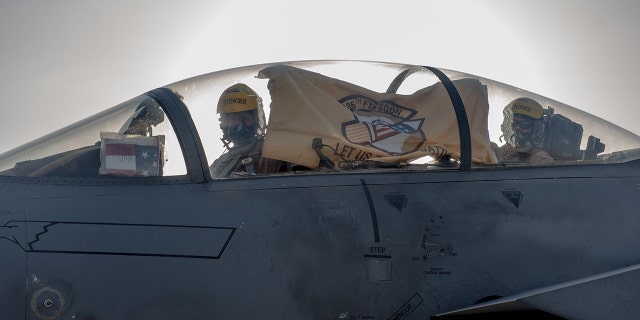 F-15E Strike Eagle aircrew hold up their 336th Fighter Squadron flag, June 13, 2019, at Al Dhafra Air Base, United Arab Emirates. The 336th FS deployed from the 4th Fighter Wing at Seymour Johnson AFB, North Carolina, bringing additional air power to Team ADAB.