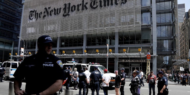New York Police officers, pictured here taking activists into custody, arrested 70 people during a climate change rally outside of The New York Times building on Saturday.
