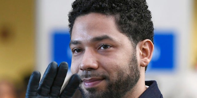 In this March 26, 2019, file photo, actor Jussie Smollett waves as he leaves Cook County Court after his charges were dropped in Chicago.