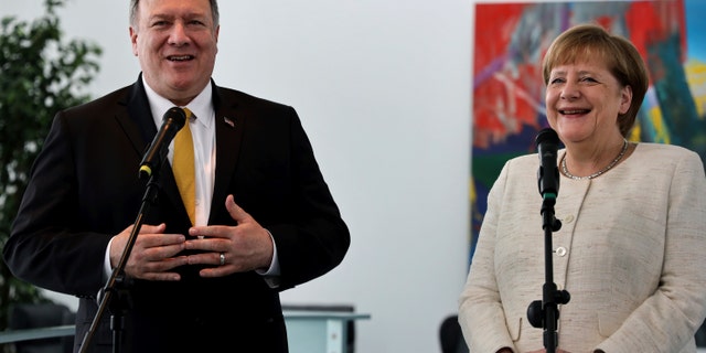 U.S. Secretary of State, Mike Pompeo, left, and German Chancellor Angela Merkel, right, address the media during a joint statement prior to a meeting at the chancellery in Berlin, Germany, Friday, May 31, 2019. (AP Photo/Michael Sohn)