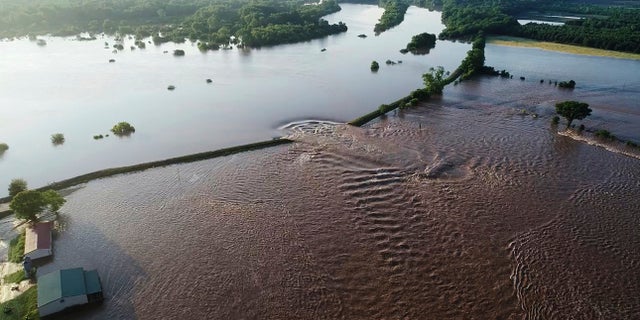 In this aerial image provided by Yell County Sheriff's Department water rushes through the levee along the Arkansas River in Dardanelle, Ark., on Friday. Officials say the levee breached early Friday at Dardanelle, about 60 miles northwest of Little Rock. (Yell County Sheriff's Department via AP)
