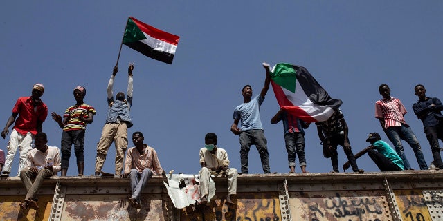 FILE - In this May 2, 2019, file photo, Sudanese protesters wave national flags at the sit-in outside the military headquarters, in Khartoum, Sudan. (AP Photos/Salih Basheer, File)