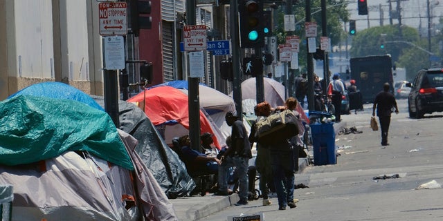 FILE - In this May 30, 2019 file photo tents housing homeless line a street in downtown Los Angeles. (AP Photo/Richard Vogel,File)