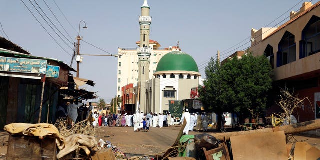 Worshipers gather at a mosque behind a roadblock set by protesters on a main street in the Sudanese capital Khartoum to stop military vehicles from driving through the area on Wednesday, June 5, 2019.