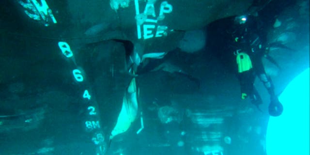 This undated photograph from the United Arab Emirates' Mission to the United Nations released Thursday, June 6, 2019, shows a diver investigating the damage done to the Saudi-owned oil tanker Al Marzoqah off the coast of Fujairah, United Arab Emirates.