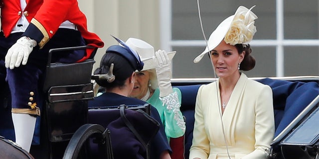 Britain's Camilla, the Duchess of Cornwall, left, Kate, the Duchess of Cambridge and Meghan, the Duchess of Sussex ride in a carriage to attend the annual Trooping the Colour Ceremony 