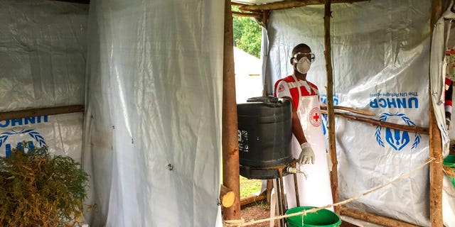 This photo taken Monday, June 10, 2019 and released by the International Rescue Committee (IRC), shows an Ebola screening checkpoint where people crossing from Congo go through foot and hand washing with a chlorine solution and have their temperature taken, at the Bunagana border crossing with Congo, in western Uganda.