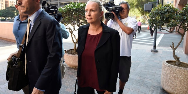 In this Thursday, Aug. 23, 2018 file photo, Margaret Hunter, center, the wife of U.S. Rep. Duncan Hunter, arrives for an arraignment hearing in San Diego. Rep. Duncan Hunter's, wife, Margaret Hunter, is planning to change her not-guilty plea after the couple was charged with using more than $250,000 in campaign funds on vacations and other expenses. (AP Photo/Denis Poroy)