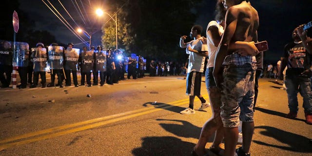 A man identified as Sonny Webber, right, father of Brandon Webber who was reportedly shot by U.S. Marshals earlier in the evening, joins a standoff as protesters take to the streets of the Frayser community in anger against the shooting. (Associated Press)