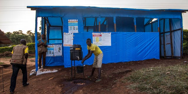 This photo released by the International Rescue Committee (IRC) shows a Congolese refugee boy washing his hands before entering one of the medical tents used for evaluating newly arrived Congolese for potential symptoms of Ebola, at the Kyaka refugee settlement in western Uganda Wednesday, June 12, 2019.