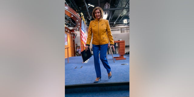 An avid sports fan, Pelosi is wearing the colors of the Golden State Warriors colors, a gold jacket with blue pants. (AP Photo/J. Scott Applewhite)
