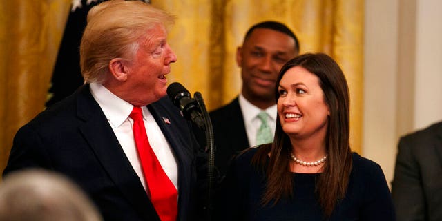 President Donald Trump welcomes White House press secretary Sarah Sanders to the stage as he pauses from speaking about second chance hiring to publicly thank the outgoing press secretary in the East Room of the White House, Thursday June 13, 2019, in Washington.