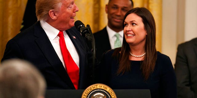 President Donald Trump welcomes White House press secretary Sarah Sanders to the stage as he pauses from speaking about second chance hiring to publicly thank the outgoing press secretary in the East Room of the White House, Thursday June 13, 2019, in Washington.