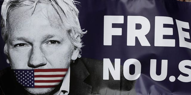 Assange supporters hold a banner to protest outside Westminster Magistrates Court in London, Friday, June 14, 2019.