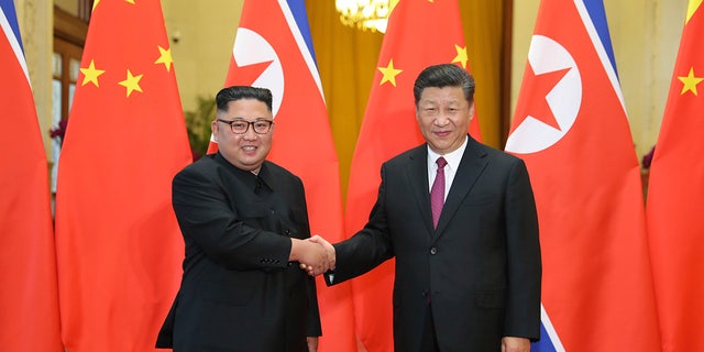 Chinese President Xi Jinping greets North Korean leader Kim Jong Un at the Great Hall of the People in Beijing on June 19, 2018.