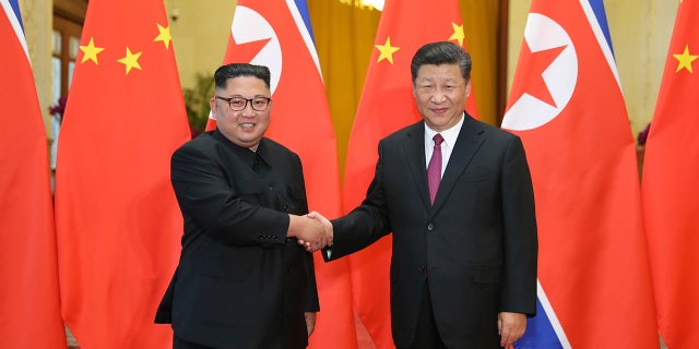 Chinese President Xi Jinping greets North Korean leader Kim Jong Un at the Great Hall of the People in Beijing on June 19, 2018.