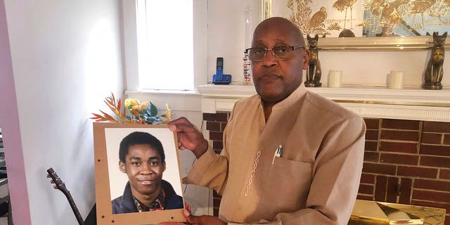 FEATURE: Dia Khafra, Askia Khafra's father, is holding a photo of his son at his home in Silver Springs, Maryland. 