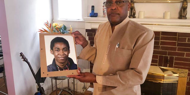 FEATURE: Dia Khafra, Askia Khafra's father, is holding a photo of his son at his home in Silver Springs, Maryland. 