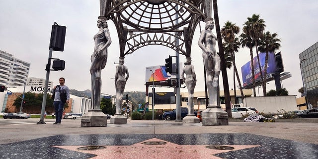 A pedestrian walks past the "Four Ladies of Hollywood" gazebo on Hollywood Boulevard in Los Angeles, on Wednesday June 19, 2019. Officials say someone climbed the more than two-story tall public art piece and stole a statue of Marilyn Monroe. Los Angeles Councilman Mitch O'Farrell says a witness saw someone climb the gazebo on the Hollywood Walk Fame and saw off the statue. (AP Photo/Richard Vogel)
