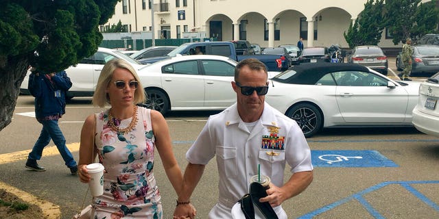 Navy Special Operations Chief Edward Gallagher, right, walks with his wife, Andrea Gallagher, as they arrive to military court on Naval Base San Diego, Thursday, June 20, 2019, in San Diego. (AP Photo/Julie Watson)