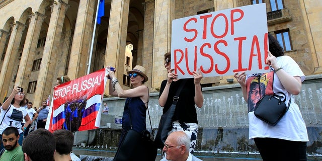 Opposition demonstrators gather in front of Georgian Parliament to call for the resignation of the speaker on Thursday. (AP Photo/Shakh Aivazov)