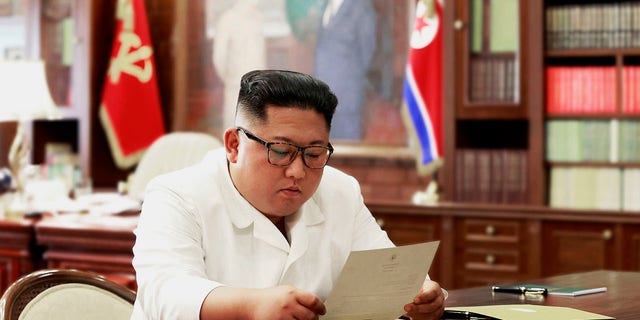 In this undated photo provided on Sunday, June 23, 2019, by the North Korean government, North Korean leader Kim Jong Un reads a letter from U.S. President Donald Trump.