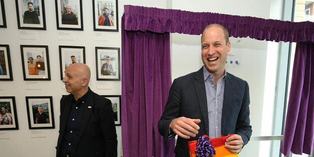 Prince William, the Duke of Cambridge, reacts to receiving a gift bag from trust chief executive officer, Tim Sigsworth, during a visit to the Albert Kennedy in London on June 26, 2019.