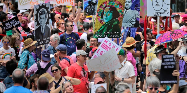 Marchers carry signs with historical LGBTQ figures during the Queer Liberation March in New York, Sunday, June 30, 2019. 