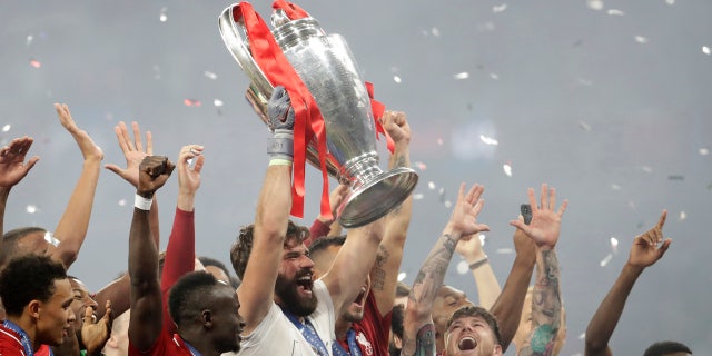 Liverpool's goalkeeper Alisson lifts the trophy as celebrates with his teammates after winning the Champions League final soccer match between Tottenham Hotspur and Liverpool at the Wanda Metropolitano Stadium in Madrid, Sunday, June 2, 2019. Liverpool won 2-0. (AP Photo/Felipe Dana)
