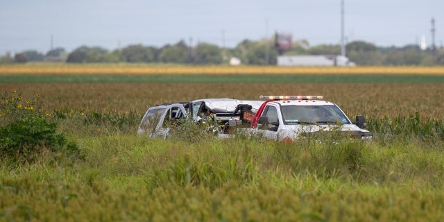 Law enforcement move a vehicle as they investigate a fatal wreck that left six migrants dead and several others injured outside Robstown, Texas on Wednesday, June 5, 2019. (Courtney Sacco/Corpus Christi Caller-Times via AP)
