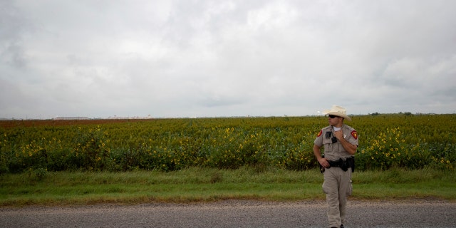 A police officer works on the scene of a fatal wreck that left six migrants dead and several others injured outside Robstown, Texas on Wednesday, June 5, 2019. (Courtney Sacco/Corpus Christi Caller-Times via AP)