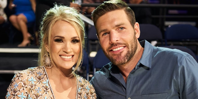 Carrie Underwood and husband Mike Fisher said faith gives them "a center ground." The couple attended the 2019 CMT Music Awards at Bridgestone Arena in Nashville, Tennessee. 