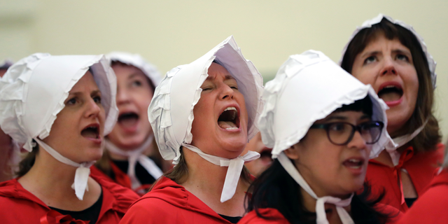 FILE - In this Tuesday, May 23, 2017 file photo, activists dressed as characters from "The Handmaid's Tale" chant in the Texas Capitol Rotunda as they protest SB8, a bill that would require health care facilities, including hospitals and abortion clinics, to bury or cremate any fetal remains whether from abortion, miscarriage or stillbirth, and they would be banned from donating aborted fetal tissue to medical researchers in Austin. (AP Photo/Eric Gay)