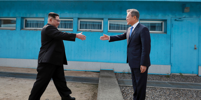 North Korean leader Kim Jong Un, left, prepares to shake hands with South Korean President Moon Jae-in over the military demarcation line in 2018. <br data-cke-eol="1">
(Korea Summit Press Pool via AP, File)