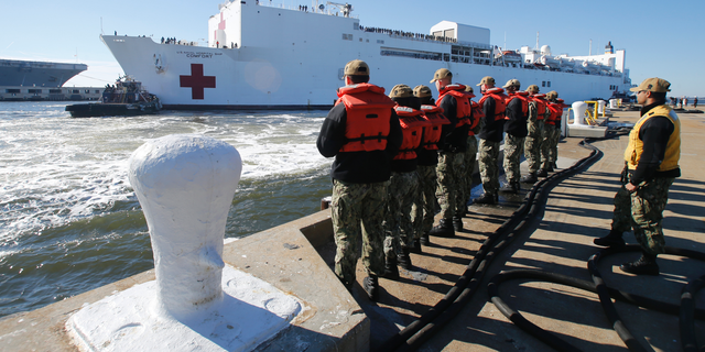 FILE - In this Dec. 18, 2018 file photo, line handlers wait as the US Navy Hospital Ship USNS Comfort arrives pier side at Naval Station Norfolk, in Norfolk , Va., after an 11-week medical support mission to South and Central America. The USNS Comfort begins on Friday, June 14, 2019, a five-month medical mission that will include 11 countries impacted by the flow of Venezuelan migration. The ship will depart Friday from Norfolk, Virginia (AP Photo/Steve Helber, File)