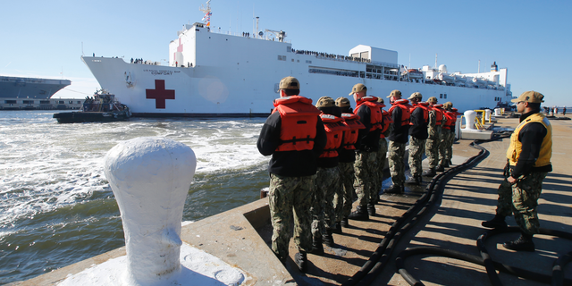 FILE - In this Dec. 18, 2018 file photo, line handlers wait as the US Navy Hospital Ship USNS Comfort arrives pier side at Naval Station Norfolk, in Norfolk , Va., after an 11-week medical support mission to South and Central America. The USNS Comfort begins on Friday, June 14, 2019, a five-month medical mission that will include 11 countries impacted by the flow of Venezuelan migration. The ship will depart Friday from Norfolk, Virginia (AP Photo/Steve Helber, File)