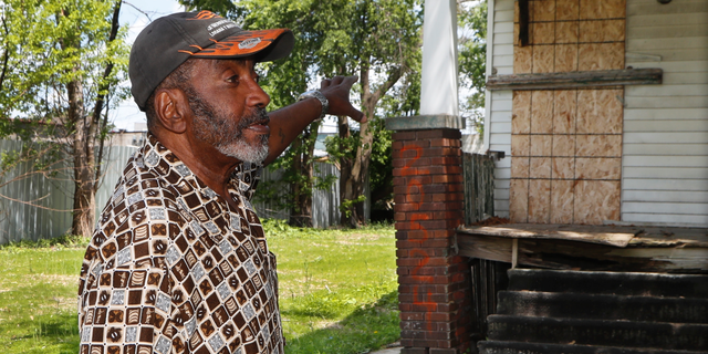 In a photo from Tuesday, June 11, 2019, Stanley Allen talks about an empty house next to his in Detroit. Hundreds of vacant houses in Detroit are being boarded up as the city responds to safety concerns following the arrest of a man suspected of killing at least three women. Since Friday, plywood has been nailed across doors and lower-level windows on more than 120 houses just south of the city's northern limits. (AP Photo/Carlos Osorio)